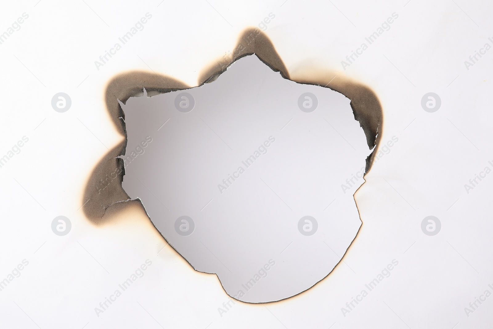 Photo of Burnt hole in paper on white background