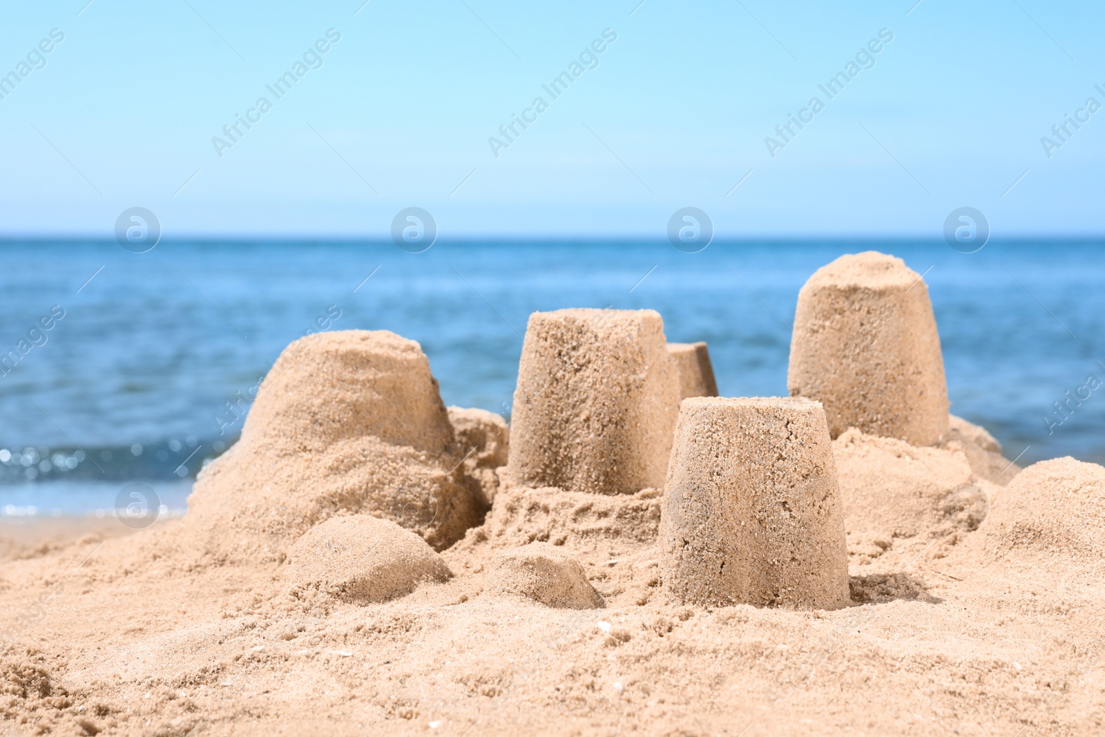 Photo of Little sand figures on beach near sea