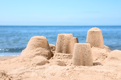 Photo of Little sand figures on beach near sea