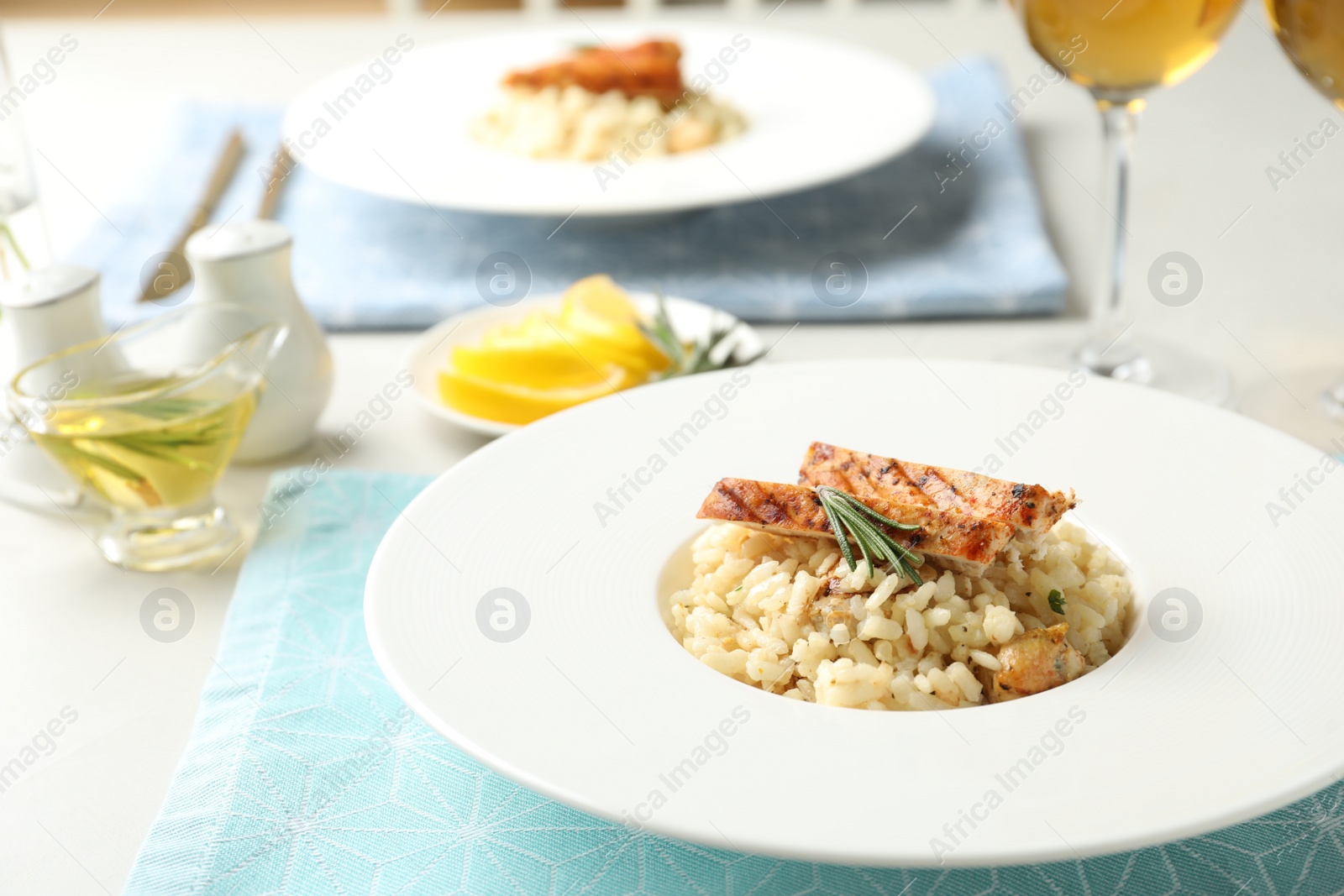 Photo of Delicious chicken risotto with rosemary served on table