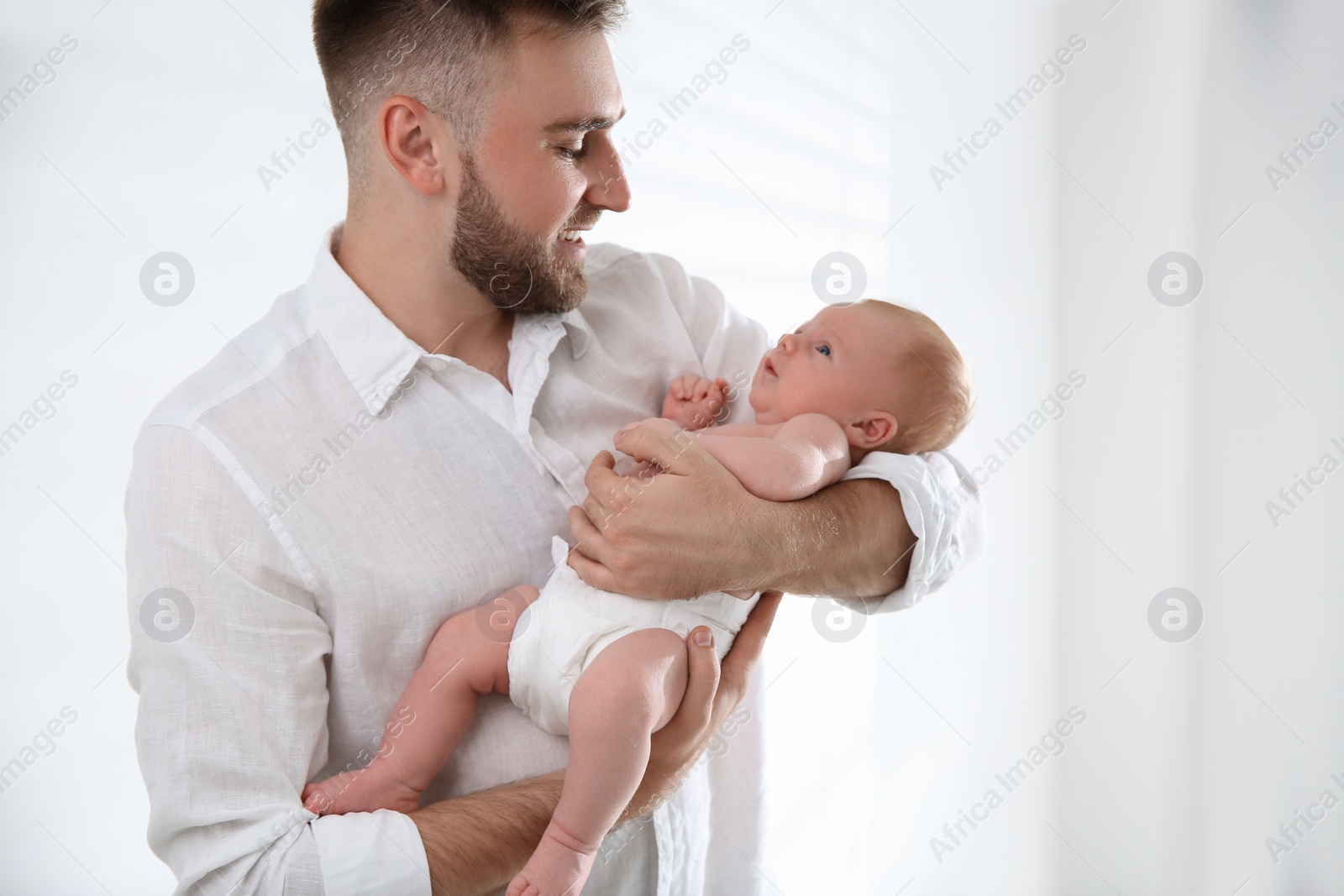Photo of Father with his newborn son on light background