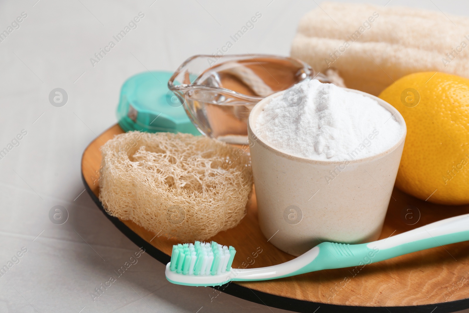 Photo of Bowl with baking soda, lemon and cleaning items on plate