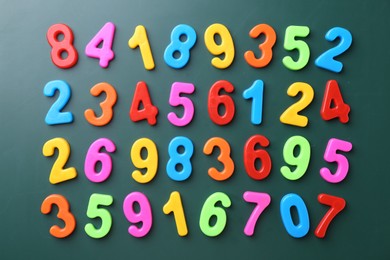 Photo of Colorful numbers on green background, flat lay