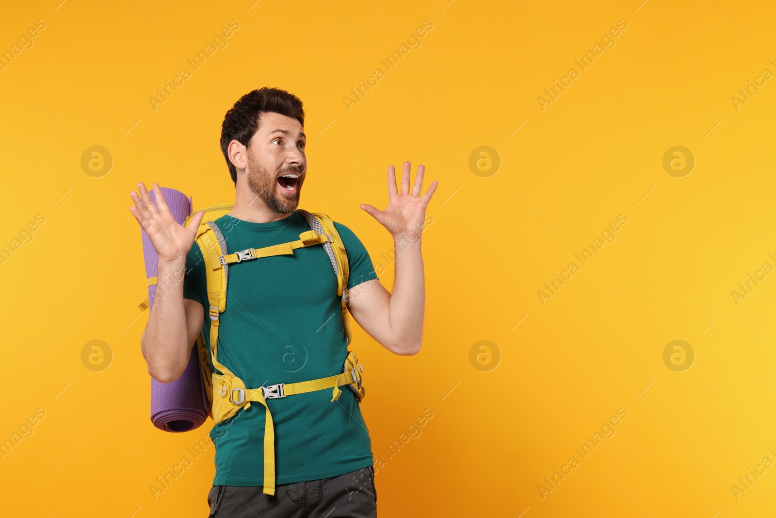 Photo of Emotional man with backpack on orange background, space for text. Active tourism