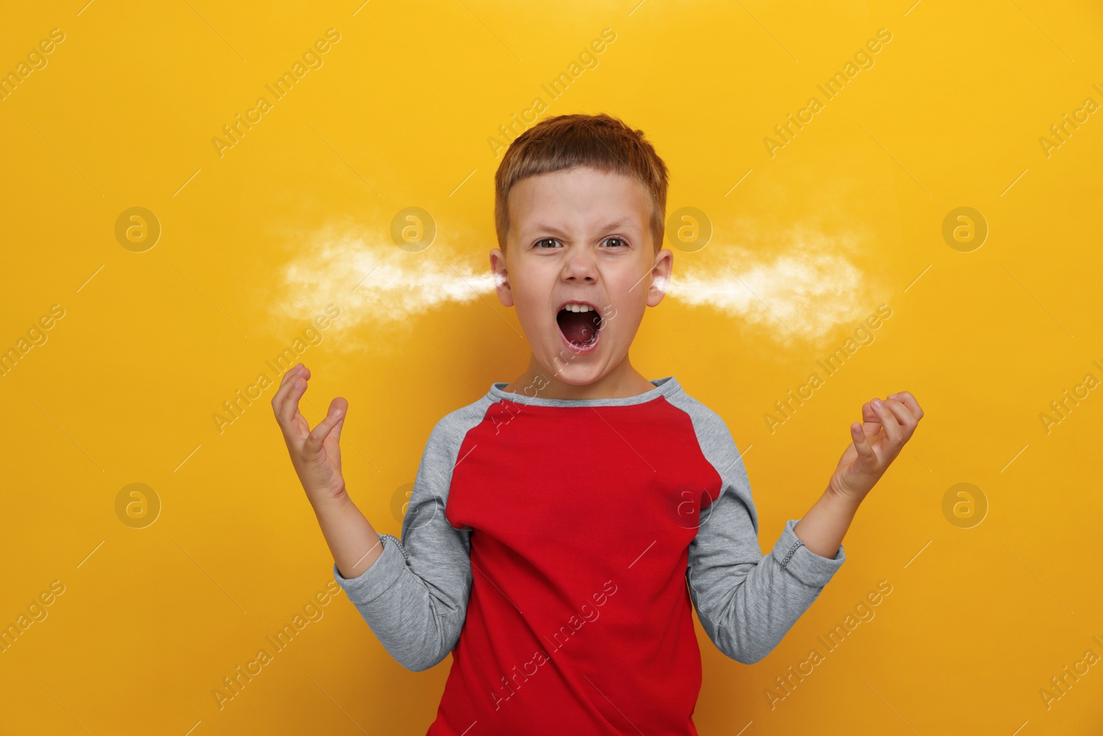 Image of Aggressive little boy with steam coming out of his ears on orange background