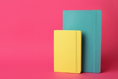 Photo of Stylish colorful planners on pink background. Space for text