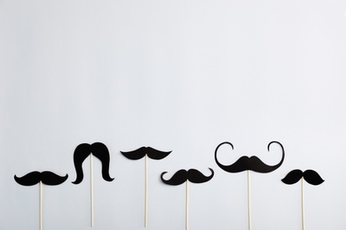 Photo of Flat lay composition with paper moustaches and space for text on gray background. Happy Father's Day