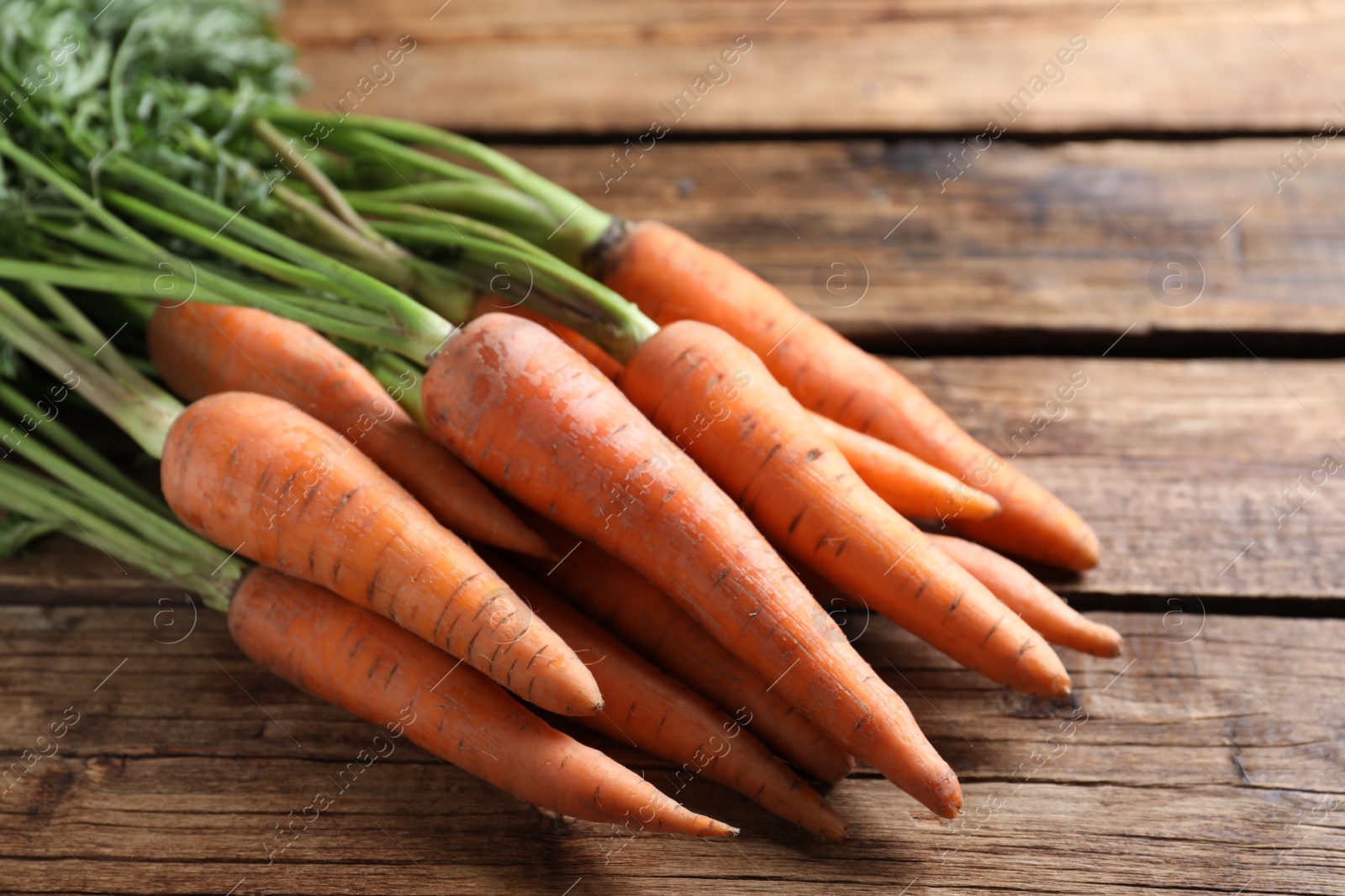 Photo of Fresh ripe carrots on wooden table, closeup