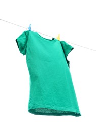 One green t-shirt drying on washing line isolated on white