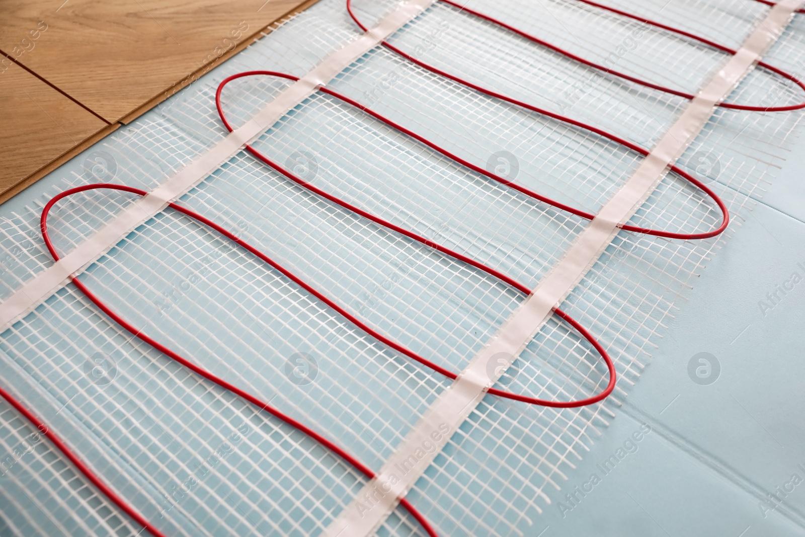 Photo of Installation of modern underfloor trace heating system indoors, closeup