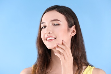 Teenage girl with acne problem against color background