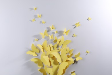 Yellow paper butterflies on white background, top view