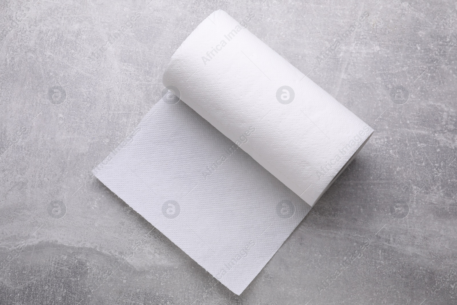 Photo of Roll of tissue towels on light grey background, top view