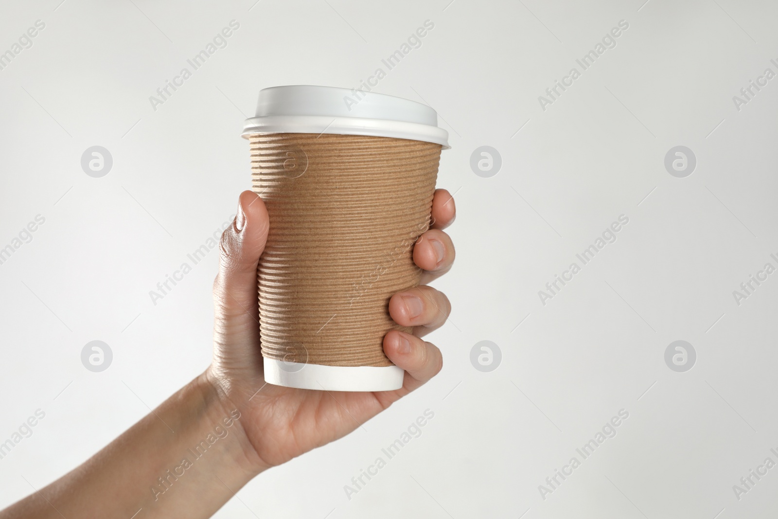 Photo of Woman holding takeaway paper coffee cup on white background, closeup. Space for text