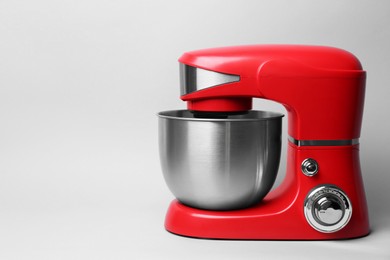 Photo of Modern red stand mixer on light grey background, space for text