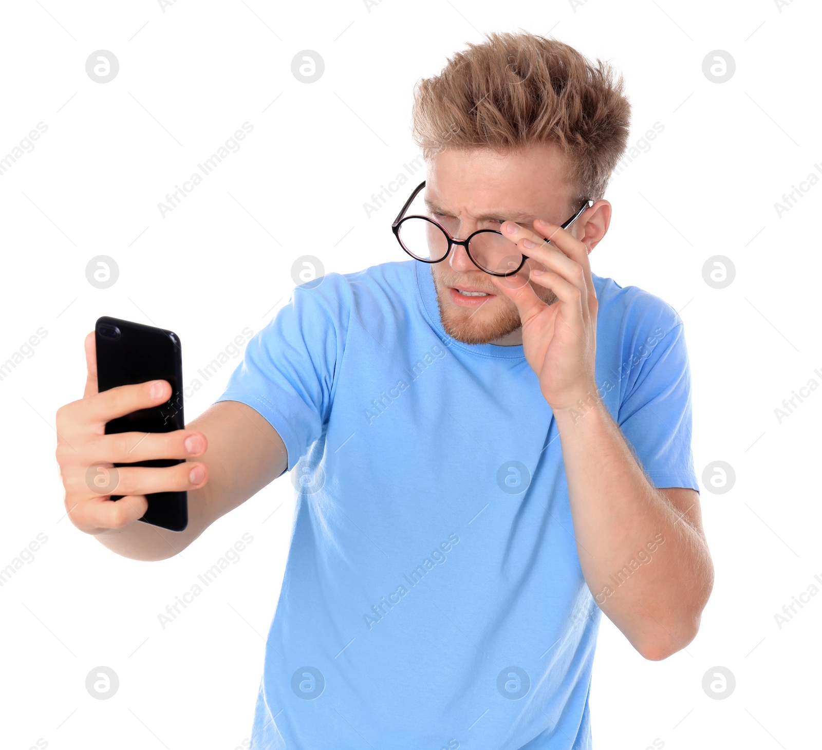 Photo of Young man with glasses using mobile phone on white background. Vision problem