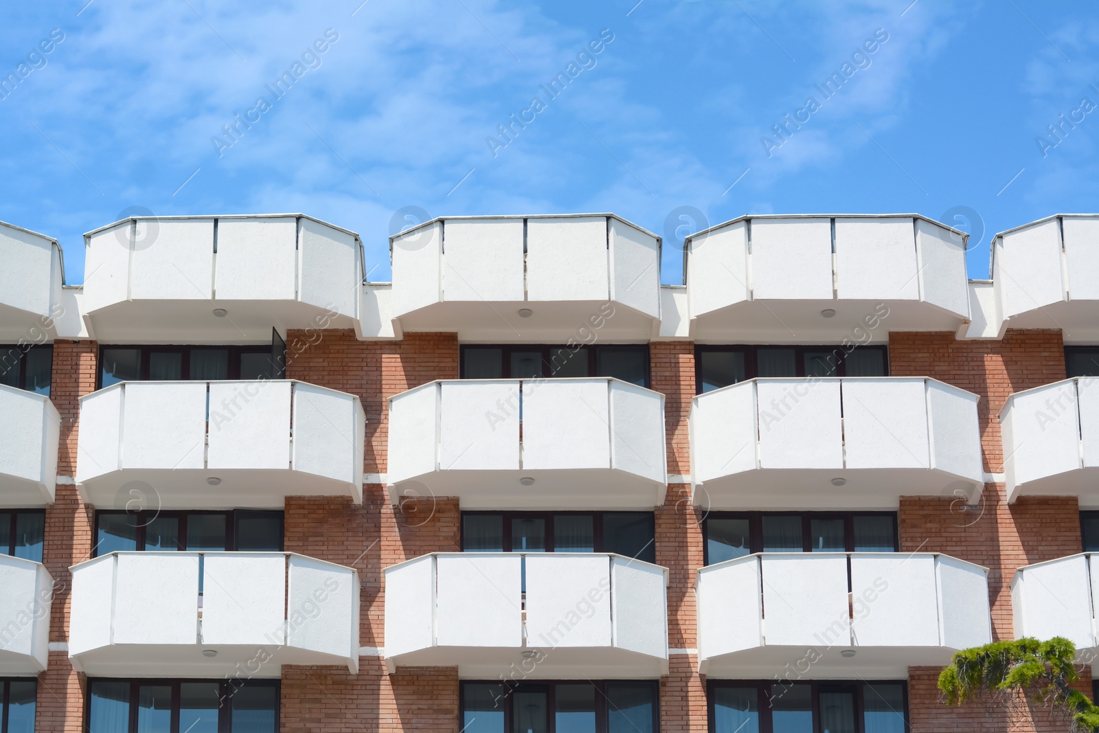 Photo of Exterior of beautiful building with balconies against blue sky