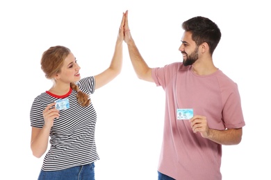 Photo of Happy young people with driving licenses on white background