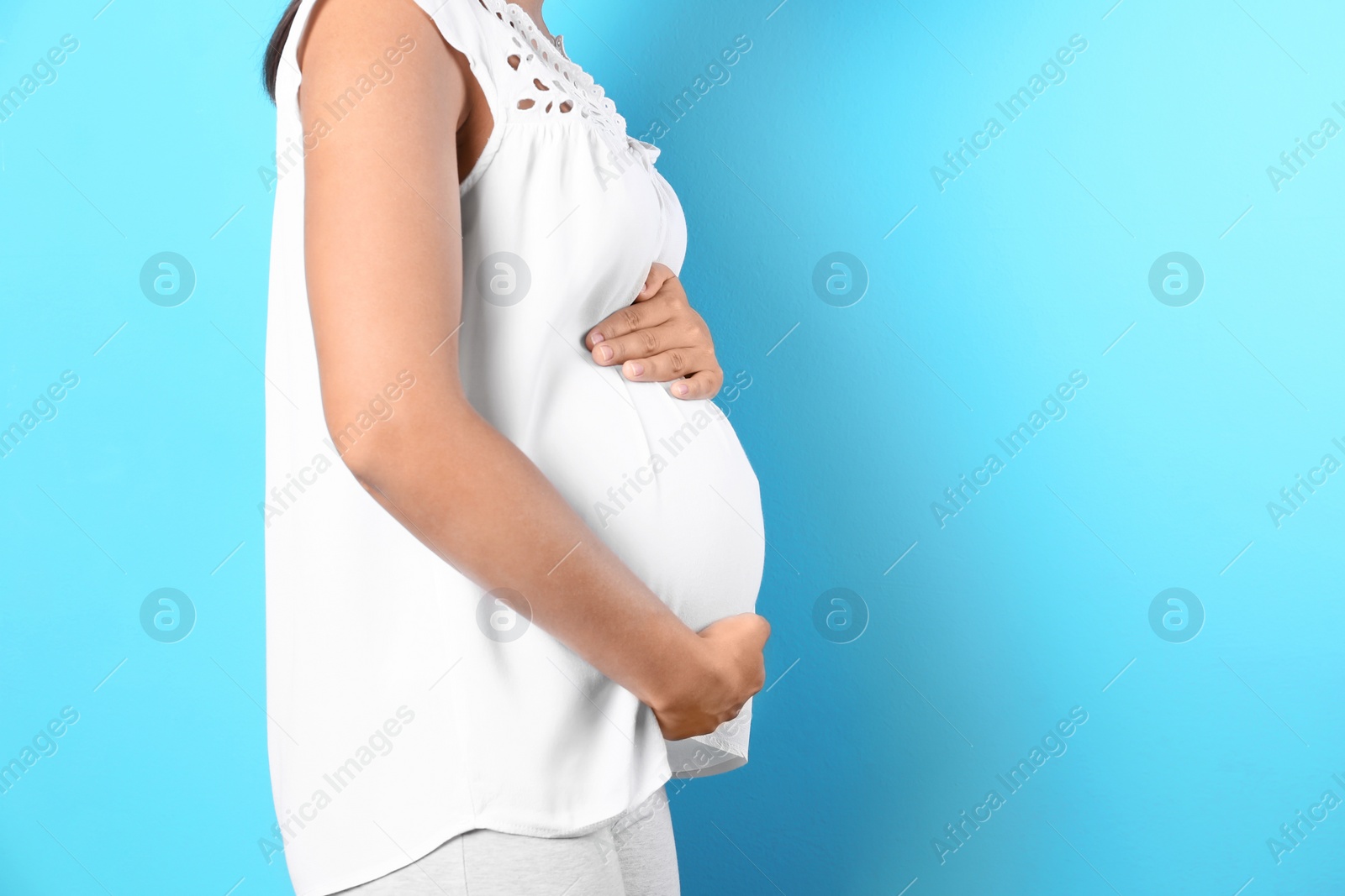 Photo of Pregnant woman posing on color background, closeup. Space for text