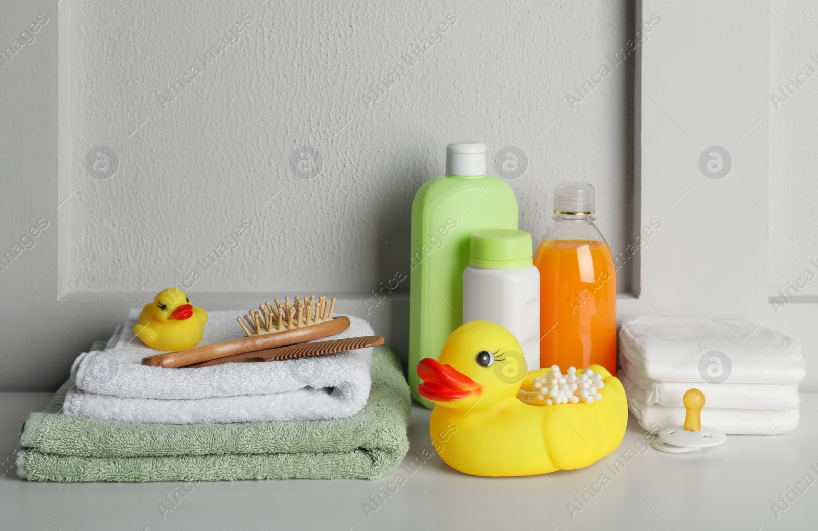 Photo of Bathroom towels, toy and baby accessories on white table