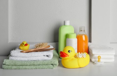 Photo of Bathroom towels, toy and baby accessories on white table