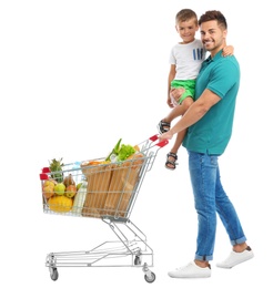 Father and son with full shopping cart on white background