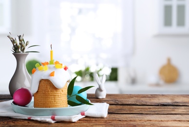 Image of Delicious Easter cake and painted eggs on wooden table indoors. Space for text