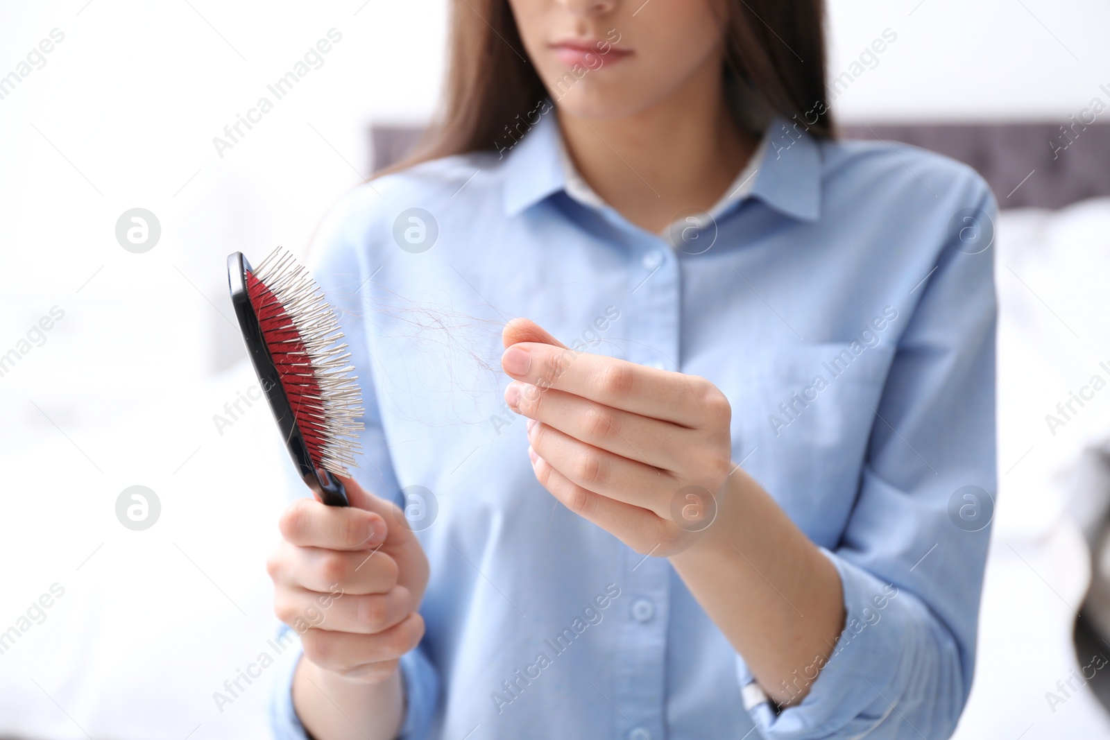 Photo of Young woman with brush indoors, closeup. Hair loss problem
