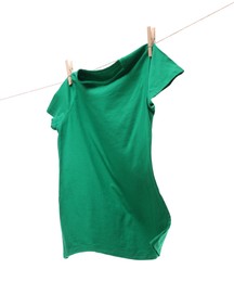 One green t-shirt drying on washing line isolated on white