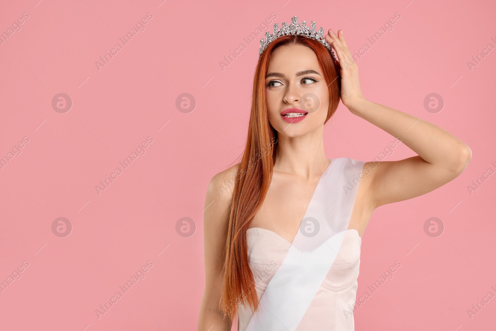 Photo of Beautiful young woman with tiara and ribbon on pink background, space for text