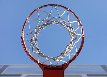 Photo of Basketball hoop with net outdoors on sunny day, bottom view