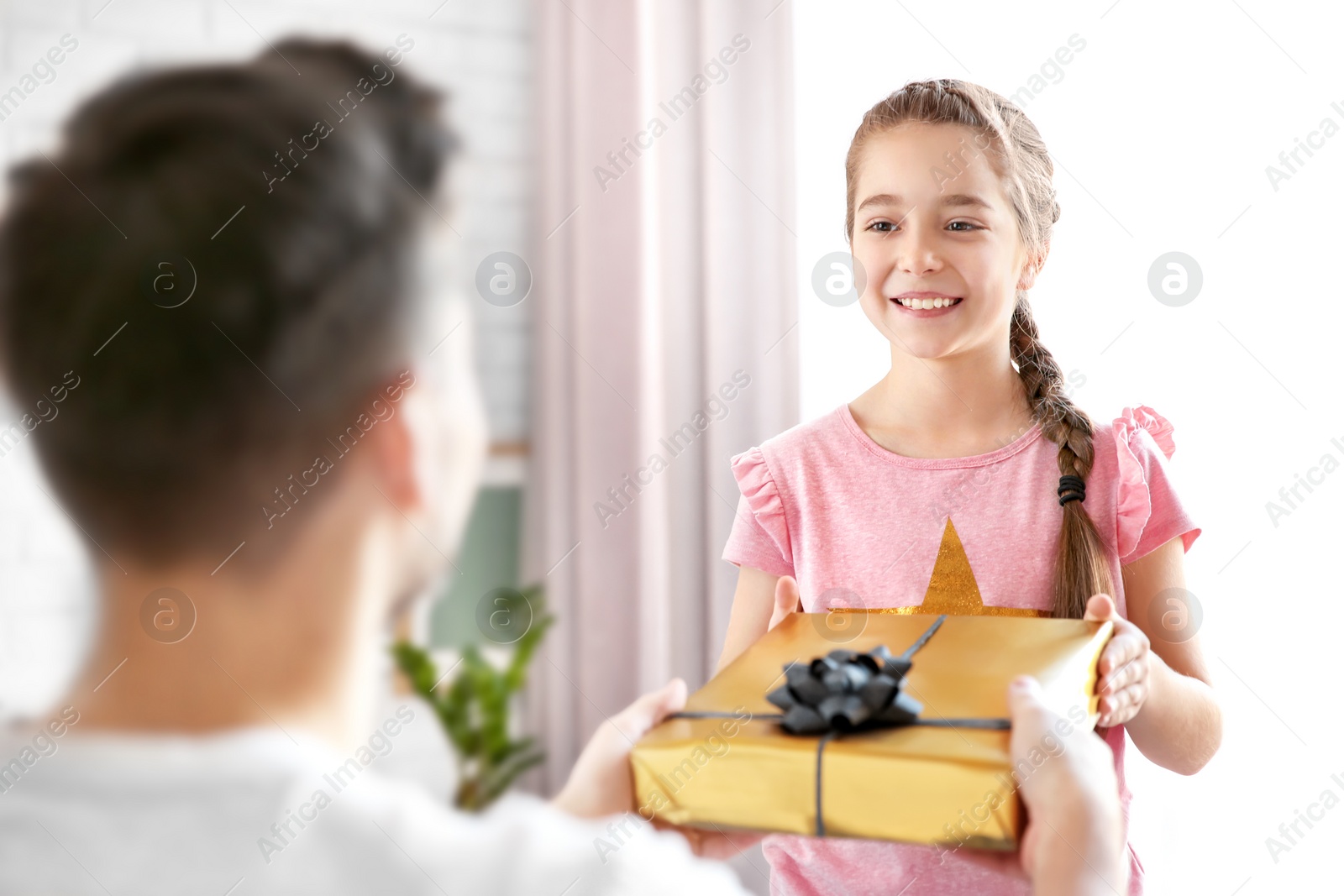 Photo of Man receiving gift for Father's Day from his daughter at home