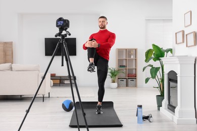 Trainer recording workout on camera at home