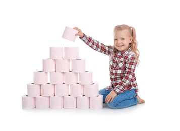 Photo of Cute little girl making toilet paper pyramid on white background