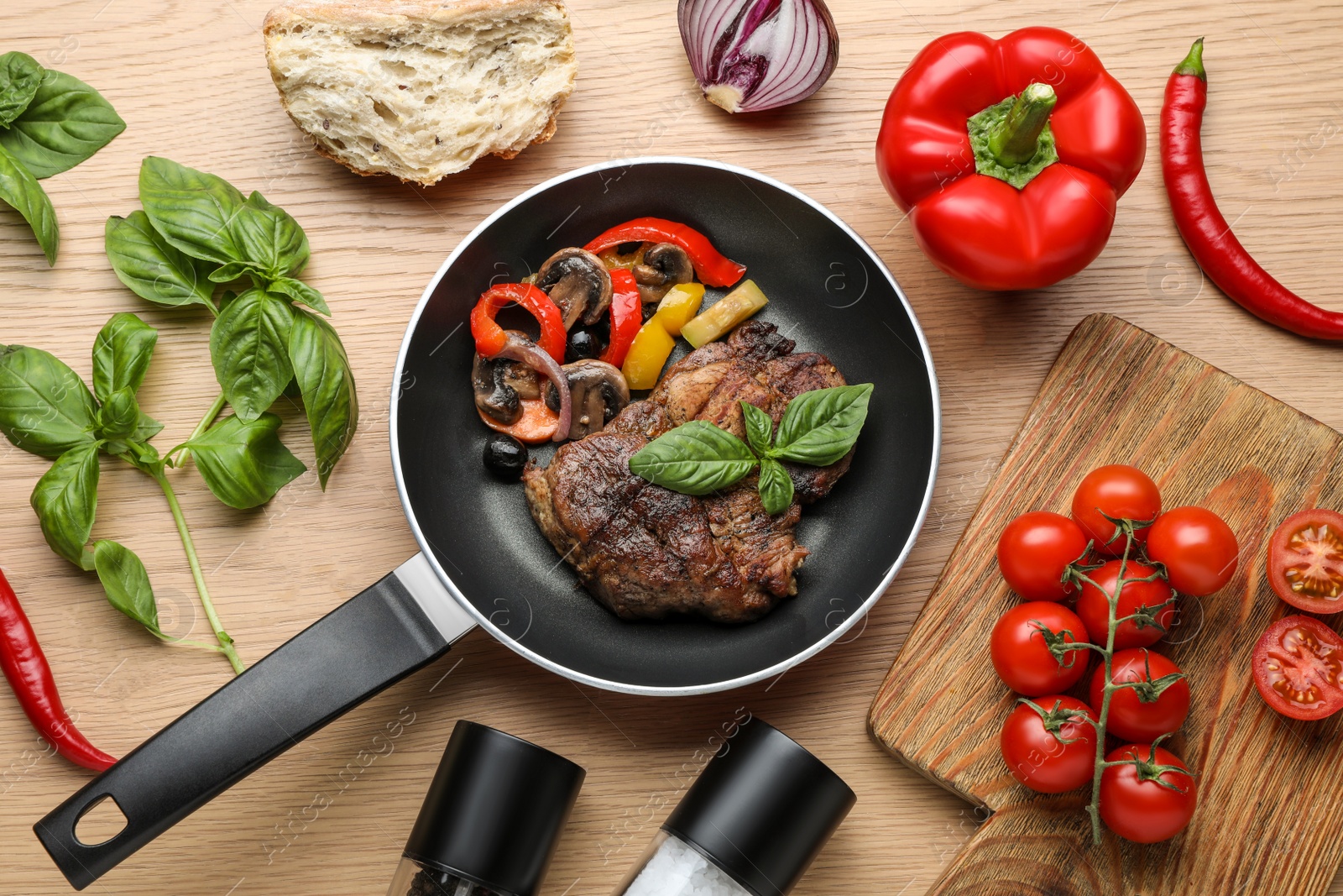Photo of Flat lay composition with delicious steak and vegetables in frying pan on wooden table