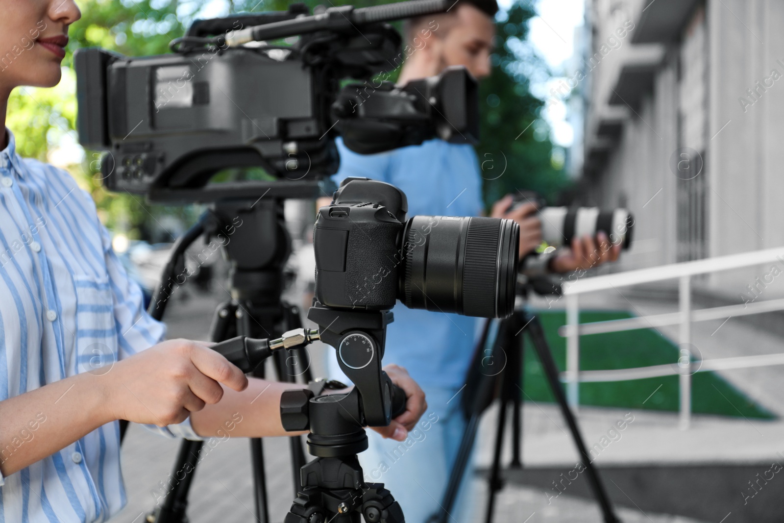 Photo of Professional video camera operators working on city street