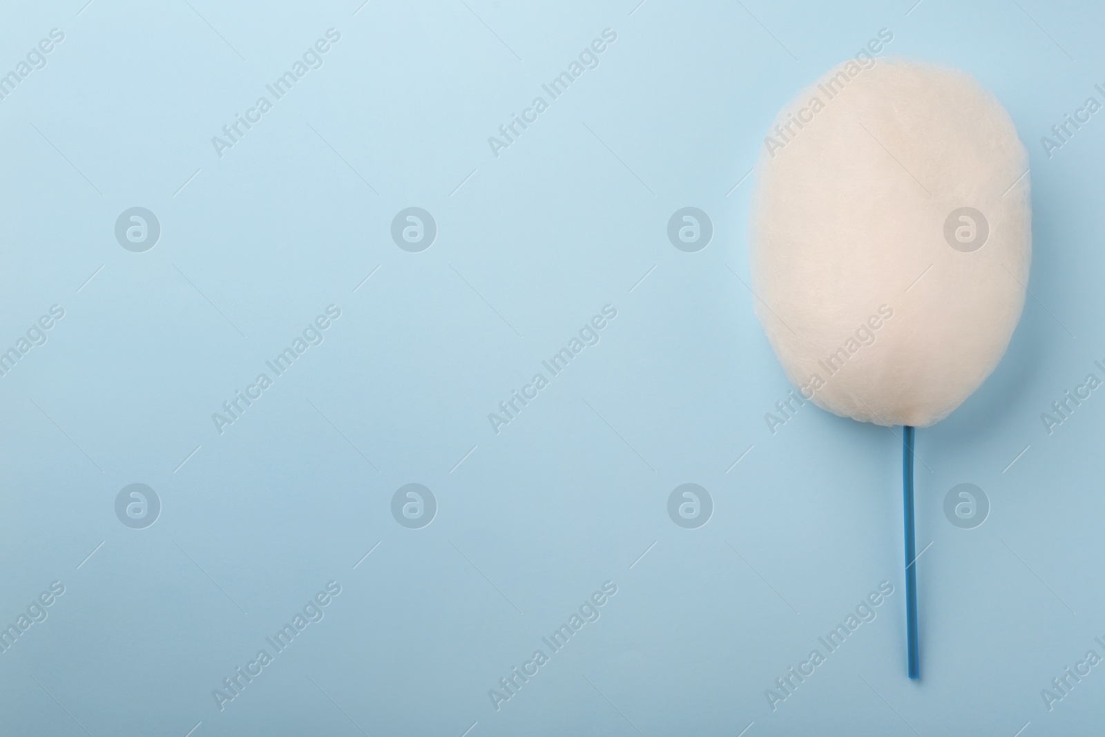 Photo of One sweet cotton candy on light blue background, top view. Space for text