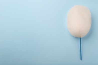 Photo of One sweet cotton candy on light blue background, top view. Space for text