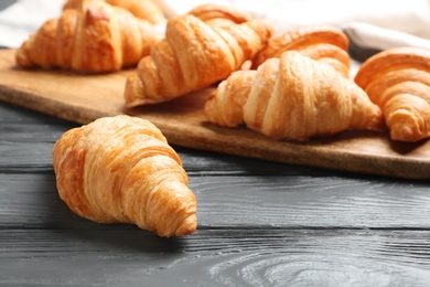 Photo of Fresh croissants on dark wooden table. French pastry
