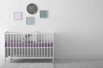 Photo of Baby room interior with crib near wall