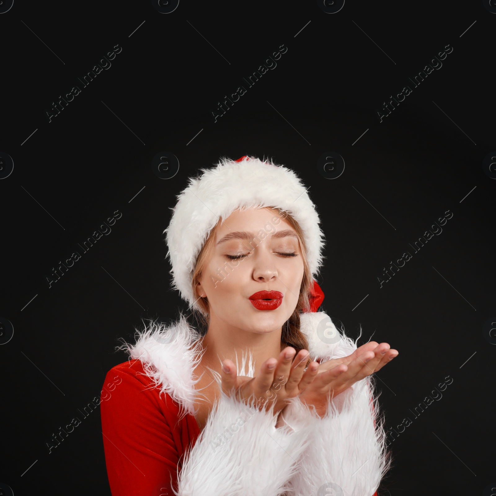 Photo of Beautiful Santa girl on black background. Christmas eve