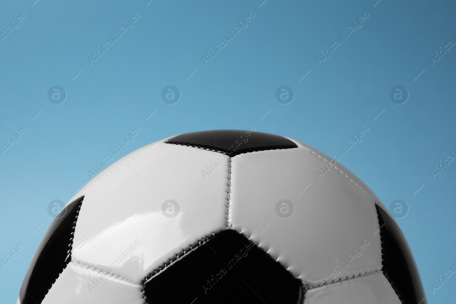 Photo of One soccer ball on light blue background, closeup. Sports equipment