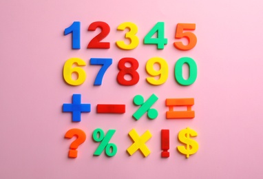 Photo of Colorful plastic magnetic numbers on color background, top view