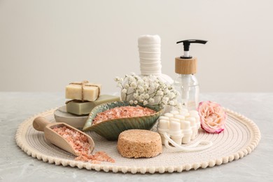 Sea salt and different spa products on light grey marble table