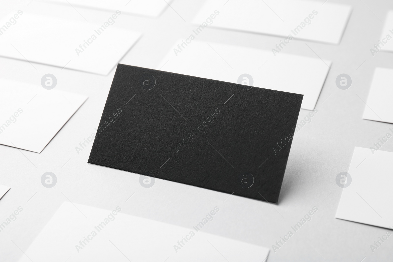 Photo of Blank black and white business cards on light background, closeup. Mockup for design