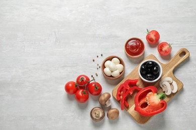 Flat lay composition with fresh pizza  ingredients on white wooden table. Space for text