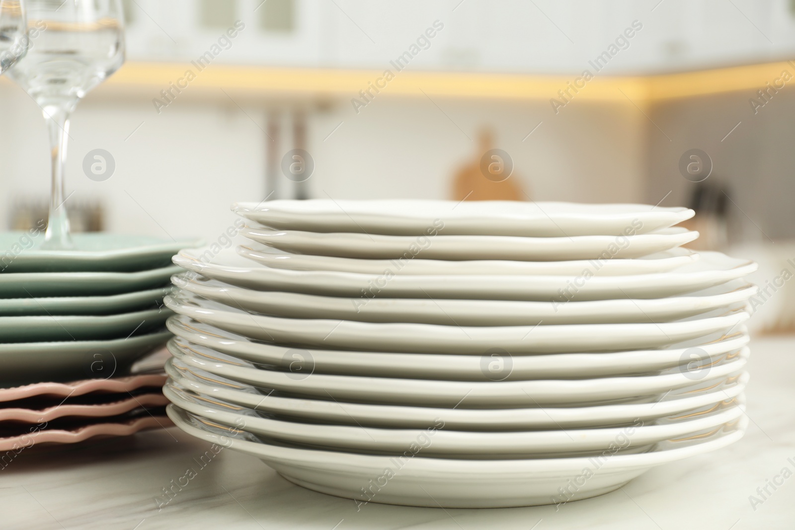 Photo of Clean plates on white marble table in kitchen