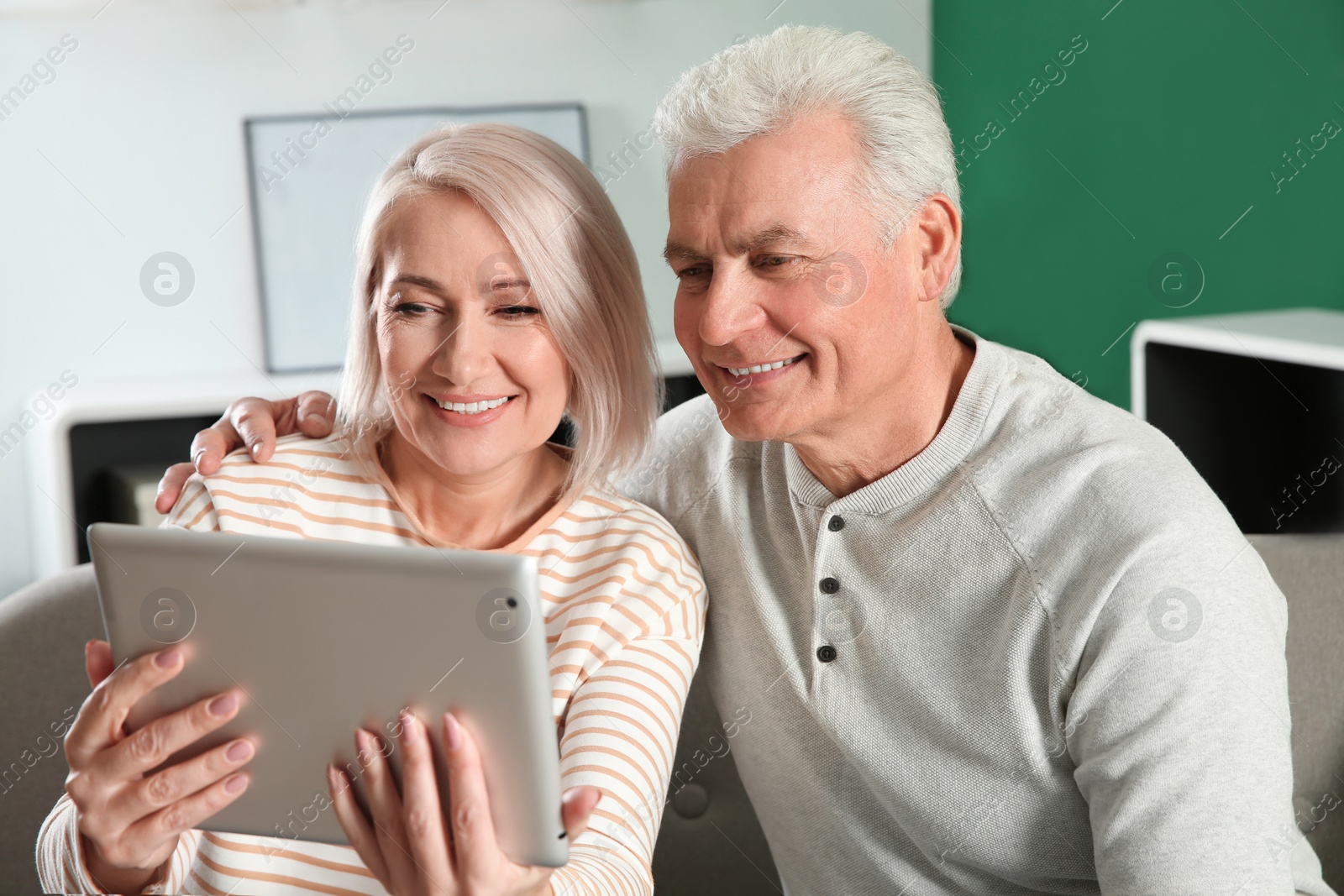 Photo of Mature couple using video chat on tablet at home