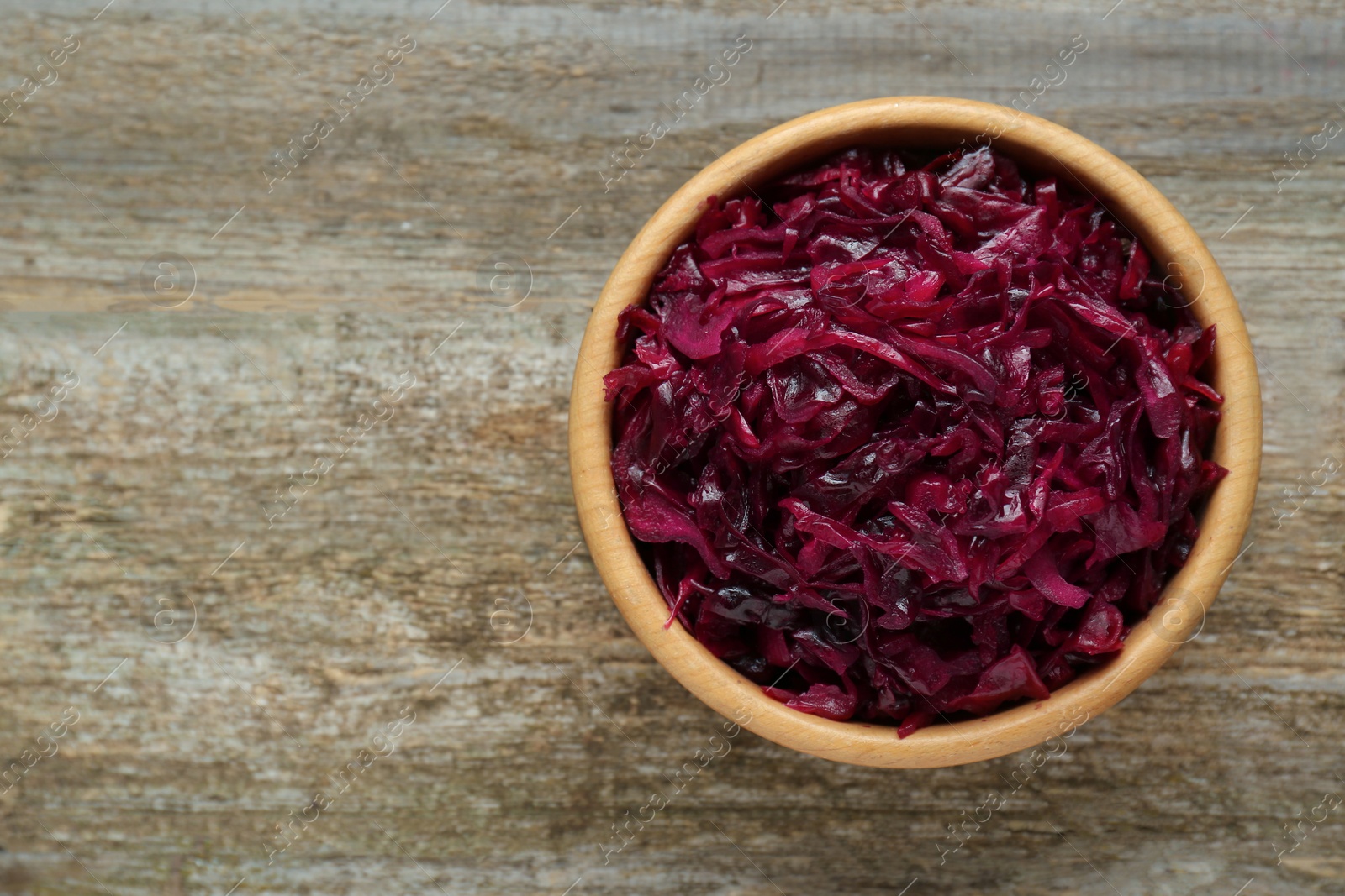 Photo of Tasty red cabbage sauerkraut on wooden table, top view. Space for text