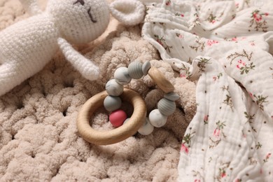 Baby accessories. Toys and cloth on knitted fabric, closeup